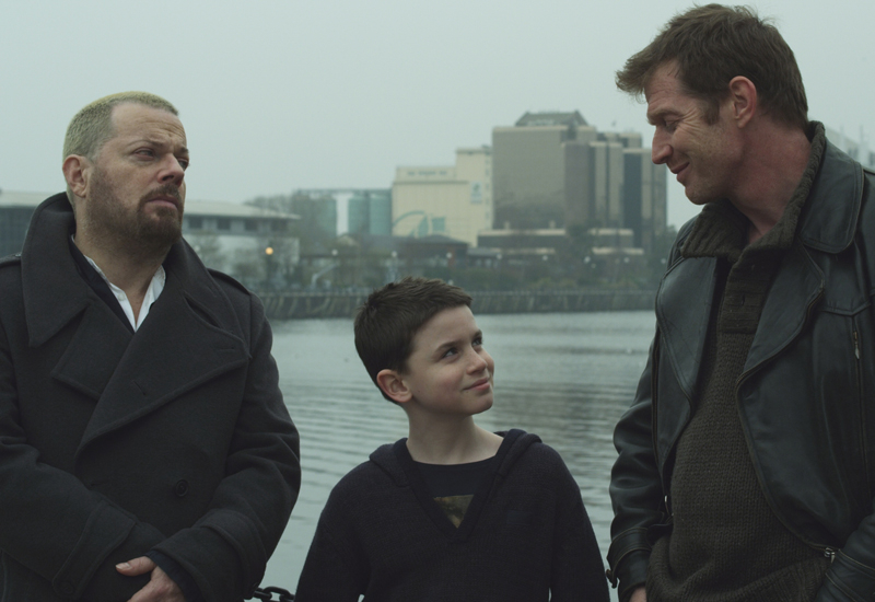 Eddie Izzard, a child and that English bloke out of City of Life pose before Manchester's imposing skyline. Eddie Izzard, a child and that English bloke out of City of Life pose before Manchester's imposing skyline.